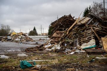 The concept of trash environmental disaster. Photo of a landfill on a street in a city on a cloudy day.