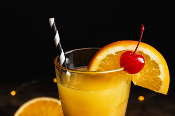 Fresh alcoholic Tequila Sunrise cocktail on dark background, closeup