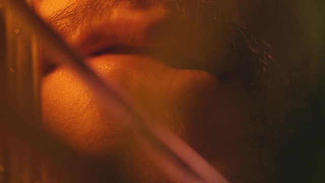 close-up of male mouth biting lips, hidden behind bush
