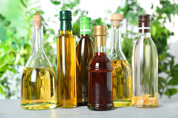 Different sorts of cooking oil in bottles on white wooden table