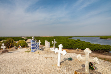 Cemetery at Joal-Fadiouth. Christian graves and crosses next to large baobabs. Fadiauth Island. Senegal. West Africa.