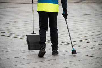 retail of les of man municipal employee with shovel and broom in hand in the street