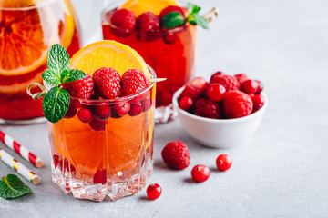 Raspberry Cranberry Sangria Punch or Mojito in glass with orange slices and mint