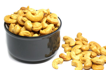 Closeup Cashew nut in black cup isolated white background - healthy food concept with copy space 