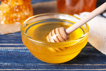 Tasty fresh honey on blue wooden table
