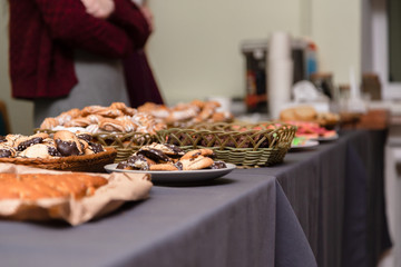 A lot of cookies lie on the grey table. blurred background. holiday or party concept. girl in the background