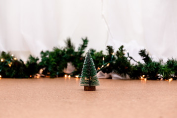Miniature christmas tree on the blurred background with christmas lights. Image for Christmas Holiday decorative concept. Minimal concept