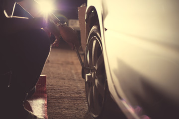 Change a flat car tire  with Tire maintenance, damaged car tyre at night.