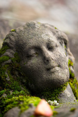 Fototapeta na wymiar Aus Stein gemeiseltes Gesicht eines schlafenden jungen Mädchens
