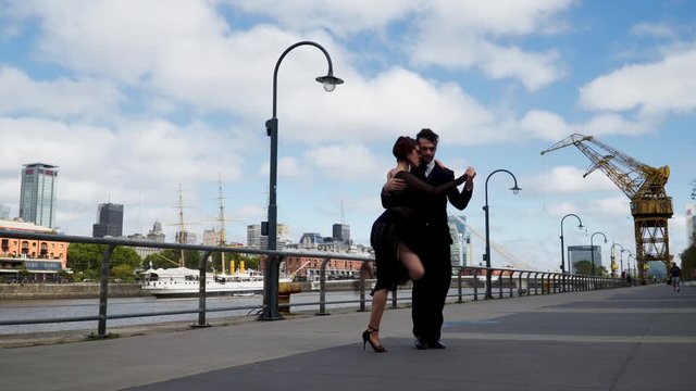 A tango dancer with his partner performing in Puerto Madero, Buenos Aires