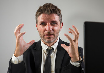 corporate business company worker in stress - attractive sad and depressed businessman working overwhelmed and desperate at office computer desk in financial executive job problems