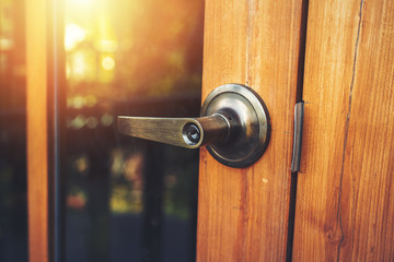 Obraz premium door knob on the wood door and light of sun.