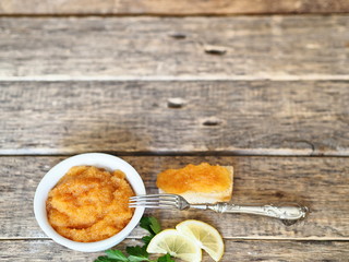 Pike river fish caviar and sandwiches on a wooden rustic ancient background.
