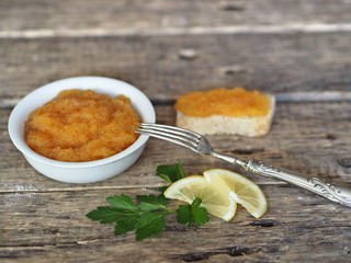 Pike river fish caviar and sandwiches on a wooden rustic ancient background.