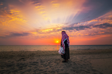 An arab old man standing in Fanateer beach with sunrise background. Al Jubail City -Saudi Arabia
