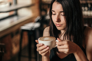 Beautiful woman drinking coffee sitting in a cafe.