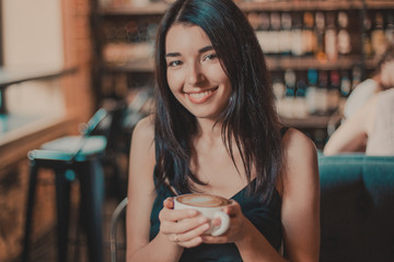 Beautiful woman drinking coffee sitting in a cafe.