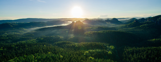 Beautiful misty forests and rocks at sunrise in the Elbe Sandstone Mountain