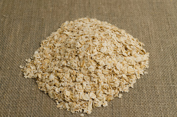  Raw oatmeal on a gray linen cloth. Oats for making porridge, proper nutrition.