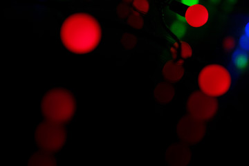 Multi-colored glare from garlands in the form of abstraction in the dark