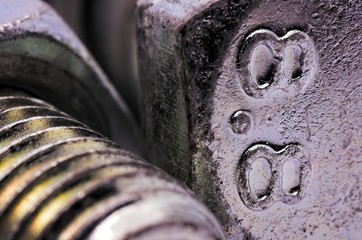 Numbers written on a bolt head. Color macro photography.