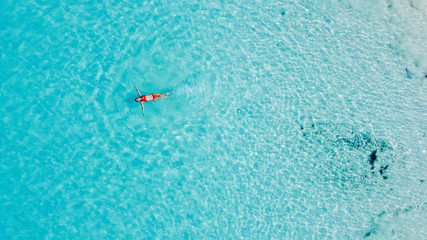 Junge Frau in rotem Bikini schwimmt im karibischen Meer