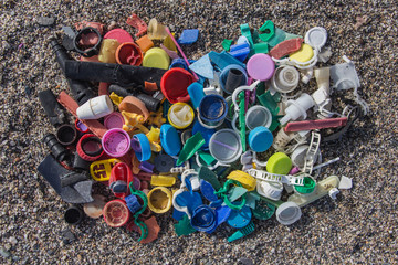 plastics thrown on the beach, spilled plastic garbage on the beach, dirty sea sandy shore