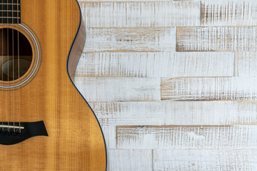 top down view of beautiful acoustic guitar on a rustic white wood background