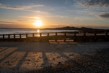 Fototapeta premium Beautiful Sunset Littlehampton Seafront, Sun casting long shadows on the sandy beach as it slip towards the horizon.