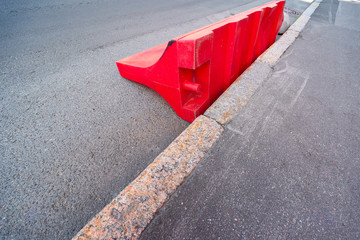 Red fallen plastic road barrier