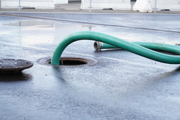 the green thick hose from a sewer pit, pumping sewage or sewage from collector in city. water...