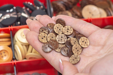 wooden buttons close-up on lodoni. Against the background of many buttons in a box. sewing and hobby concept