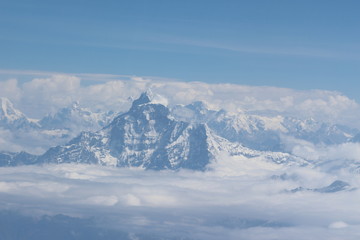 Fototapeta na wymiar A beautiful photo of a mountain with glacier and snow on it from a height above the clouds