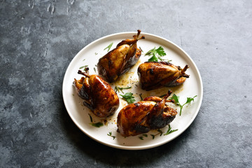 Roasted quails on white plate