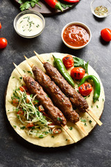 Adana Kebab with fresh vegetables on flatbread