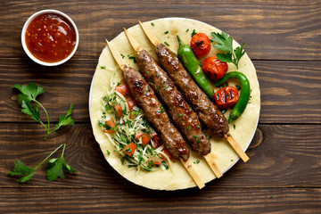 Turkish Adana Kebab with fresh vegetables on flatbread