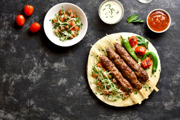 Adana Kebab with fresh vegetables on flatbread