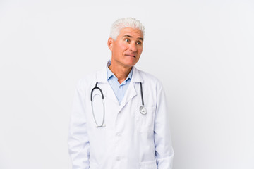 Mature caucasian doctor man confused, feels doubtful and unsure.