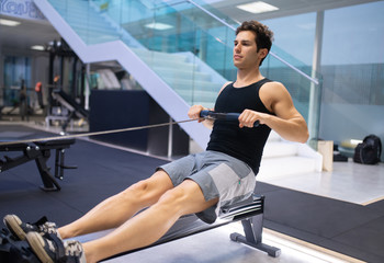 Young man working out on the rowing machine