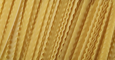 Uncooked Italian pasta mafaldine background and texture