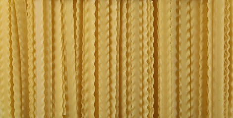 Uncooked Italian pasta mafaldine background and texture