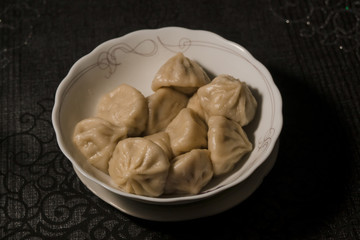 Close up of spinning plate of delicious khinkali dumplings seasoned with chili pepper