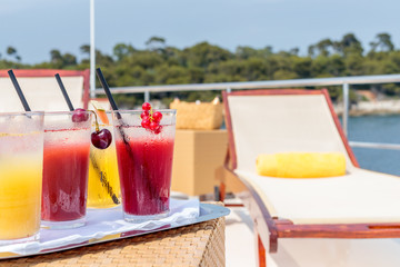 Closeup shot of red and orange drinks on a white tray
