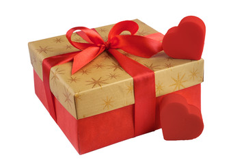 Red gift or present box with golden colored top and red ribbon bow, two hearts isolated on white background