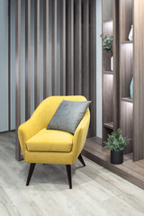 part of living room interior side view with yellow designer chair close up