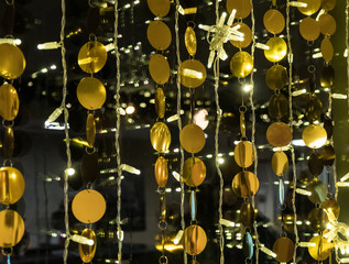 Golden balls in garlands decorate the interior. Festive attire in celebration of the New Year and Christmas. Gold and black abstract background