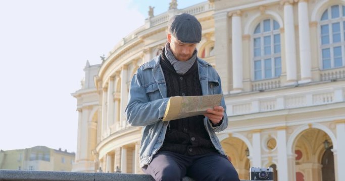 Young male traveler with map in the city	