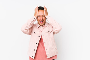 Young latin man posing isolated laughs joyfully keeping hands on head. Happiness concept.