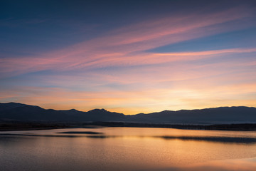 Fototapeta na wymiar Beautiful lake view on sunset. With water, mountain and colorful clouds