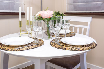 Closeup of empty wine glasses on banquet table with cutlery and Bouquet of yellow tulip flowers